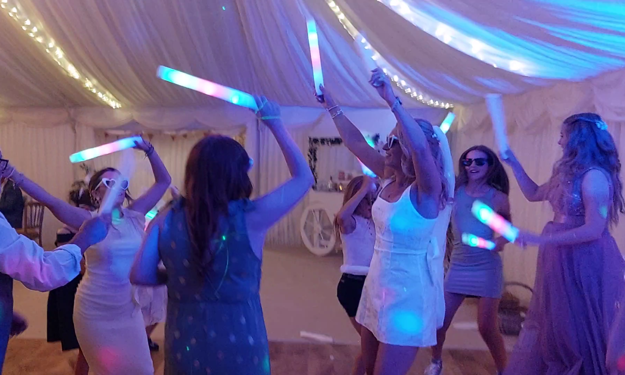 women dancing with glow sticks at a wedding